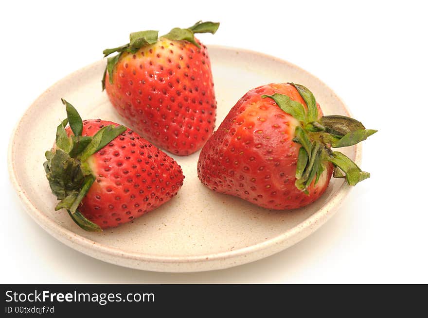 Strawberries berries on the ceramic plate, isolated on a white background