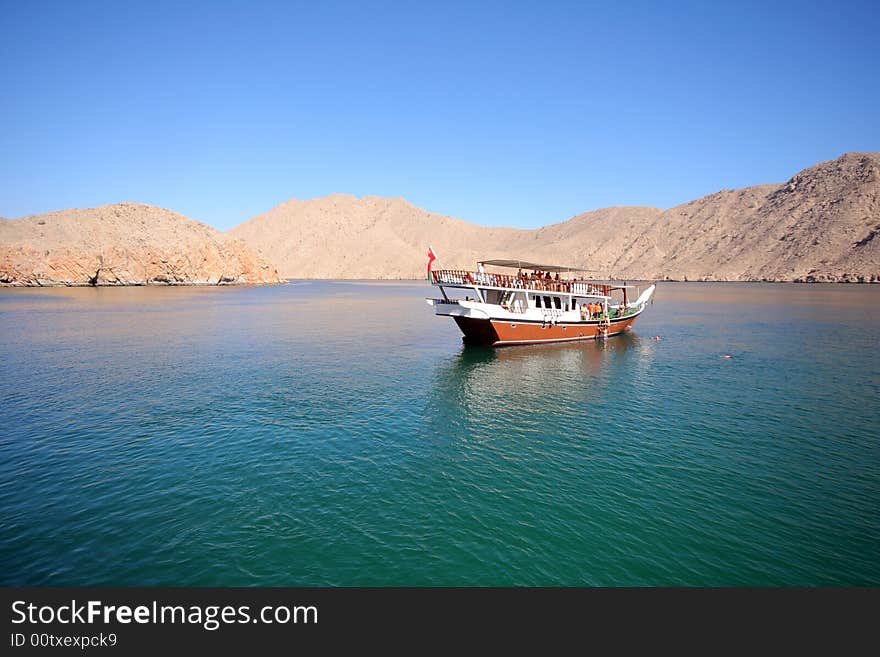 Sea ship in rocky sea bay