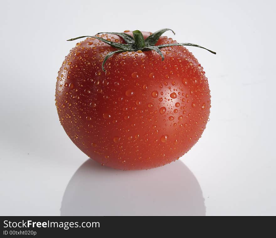 Shot of a tomato on white background with water drops. Shot of a tomato on white background with water drops