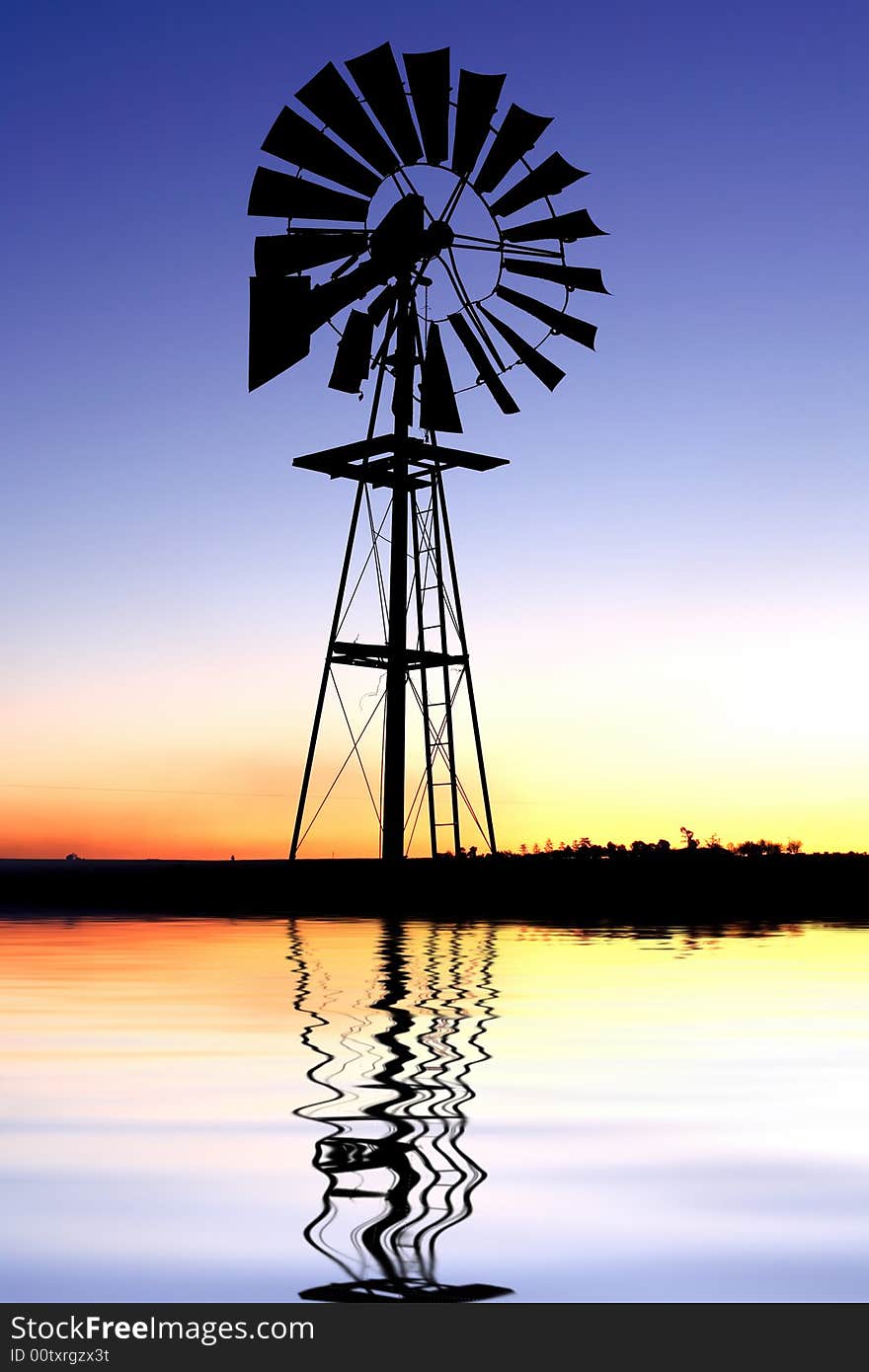 Wind pump silhouette with reflection