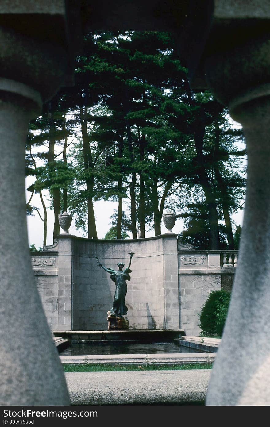 A statue behind stone fencing. A statue behind stone fencing