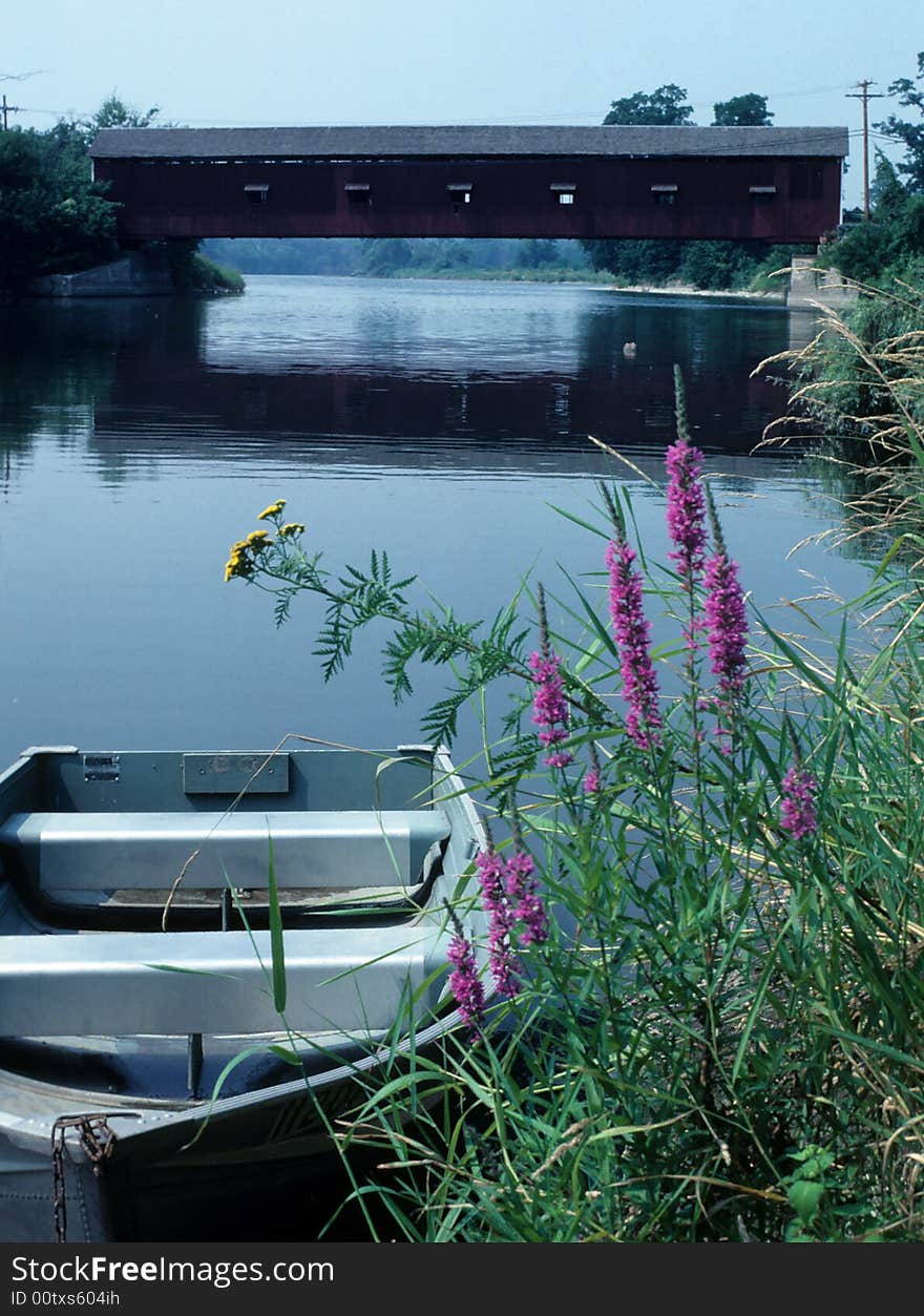 A Row boat sits tied to the shore unused. A Row boat sits tied to the shore unused