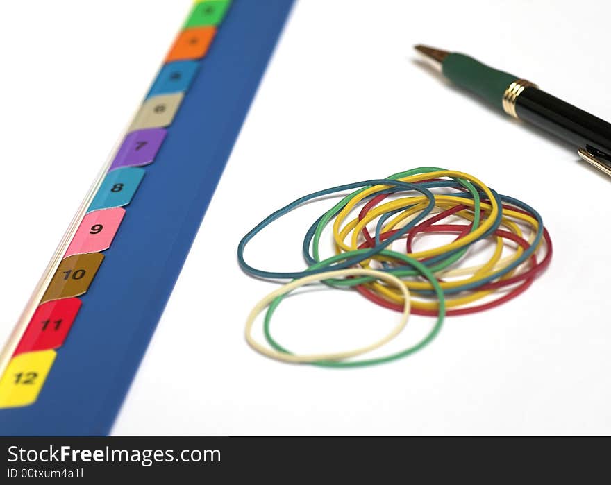 An office file with numbered dividers - one for each month, some elastic bands and a ballpoint pen. An office file with numbered dividers - one for each month, some elastic bands and a ballpoint pen.