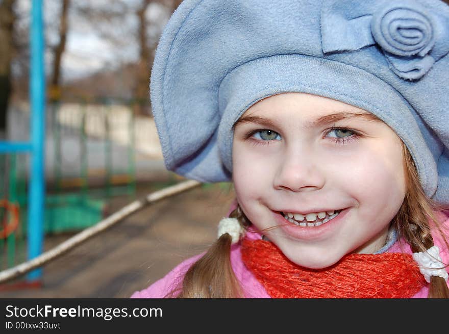 Pretty little girl outdoors wearing a big blue hat. Pretty little girl outdoors wearing a big blue hat