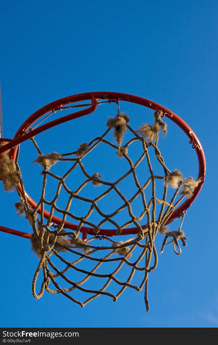 Single basketball hoop with net under the blue sky