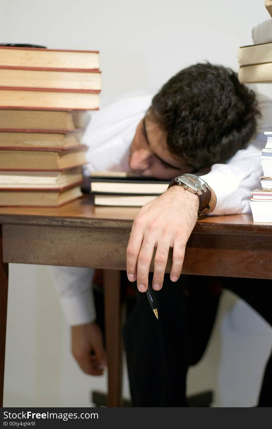 Man in business attire surrounded by books. Man in business attire surrounded by books