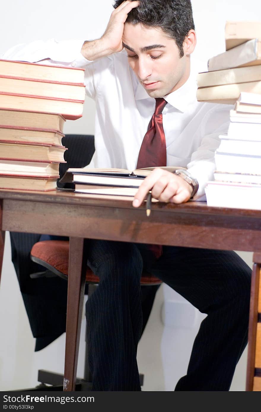 Man in business attire surrounded by books. Man in business attire surrounded by books