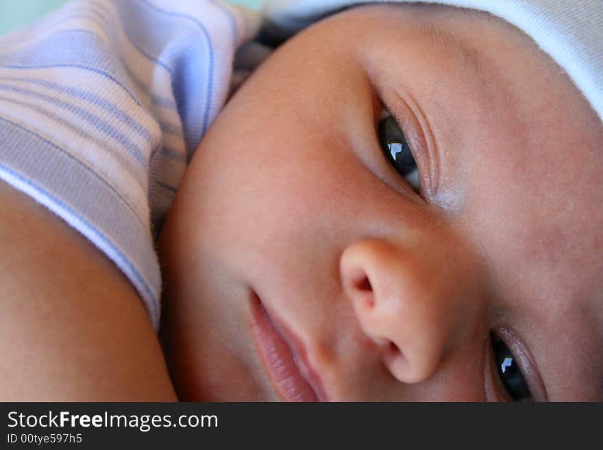 Week old baby boy on a blue blanket early in the morning. Week old baby boy on a blue blanket early in the morning