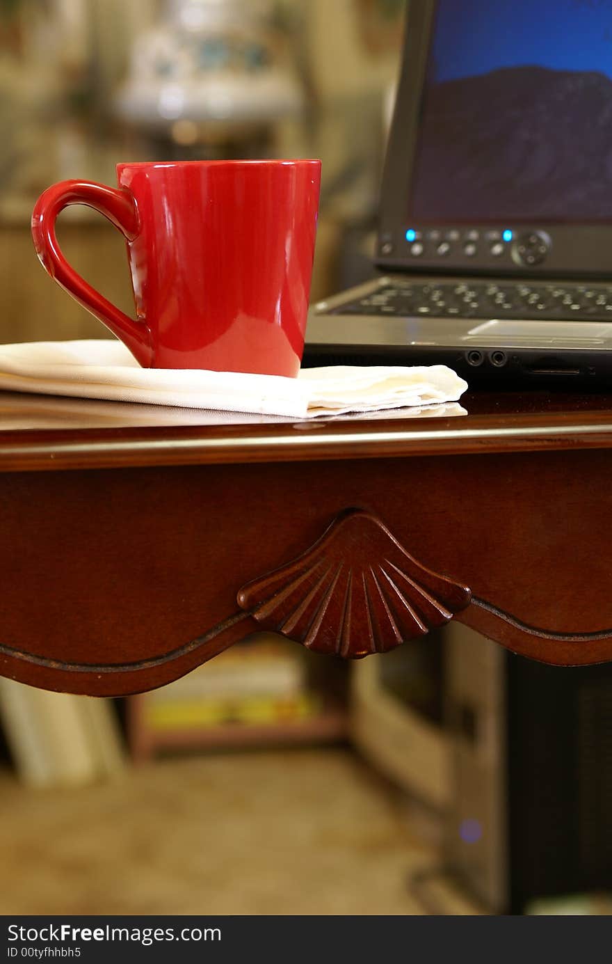 Cup of coffee on desk next to laptop computer. Cup of coffee on desk next to laptop computer