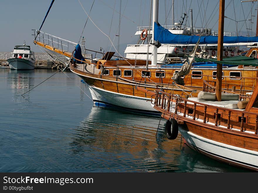 Sailing boats in silent sea harbour are reflected in water. Sailing boats in silent sea harbour are reflected in water