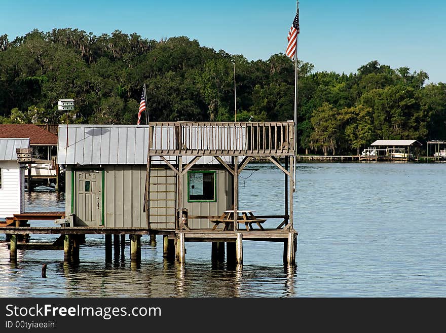 A dock house with picnic table and American flag