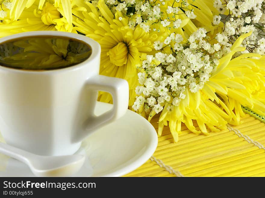 Morning cup of coffee with flowers on the table. Shallow DOF