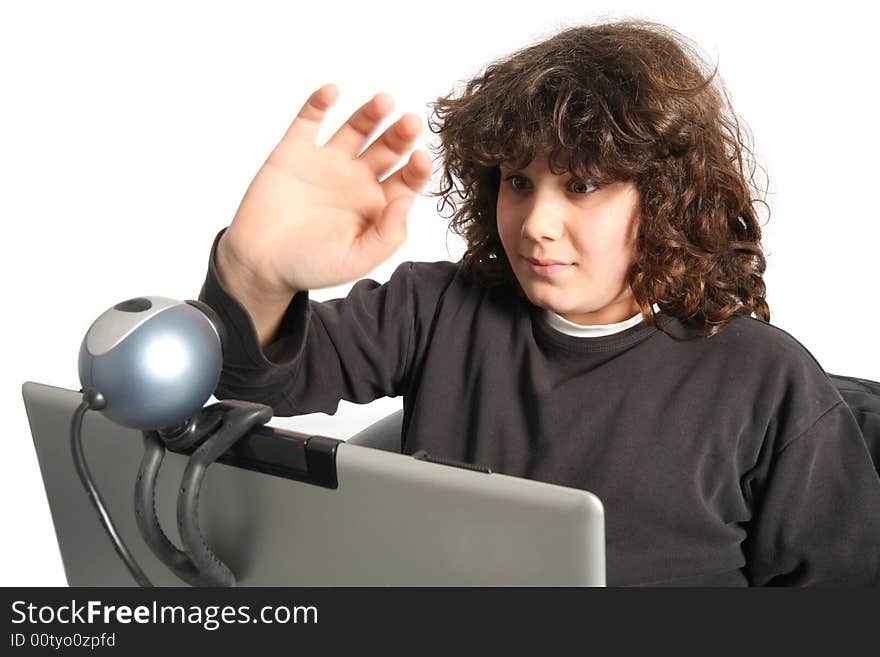 Boy using laptop, waving hand of a webcam