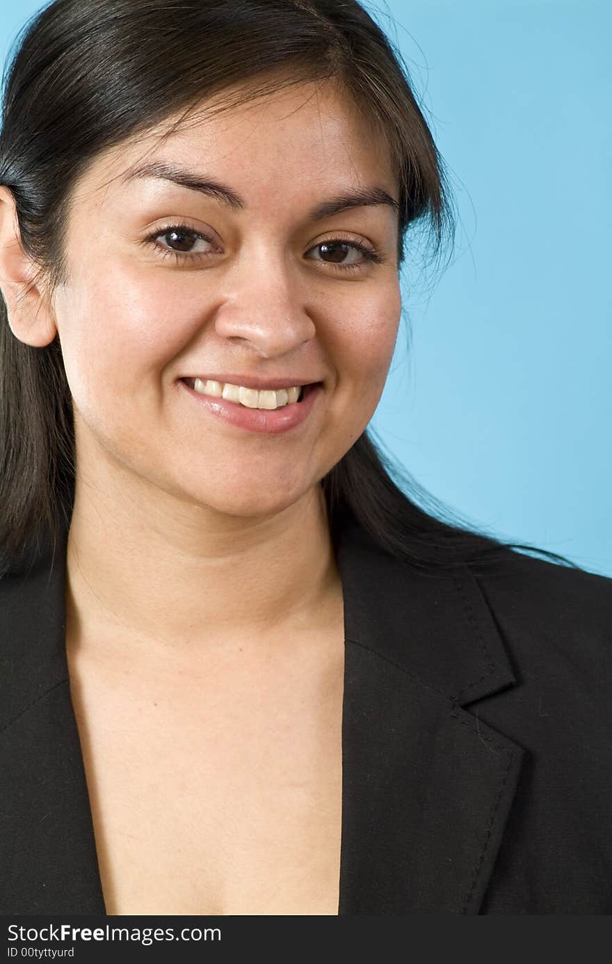 Young Hispanic girl smiling for the camera in front of a blue screen. Young Hispanic girl smiling for the camera in front of a blue screen