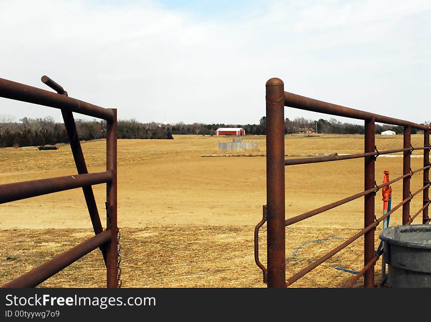 Rusted metal gate in fence opening to field at horse farm. Rusted metal gate in fence opening to field at horse farm.