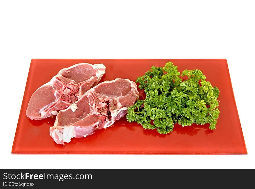 Lamb chops on red plate, white background, studio shot