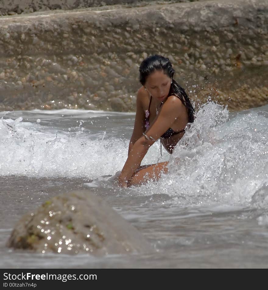 The sunbathed young white woman lays in a surf during a storm on the sea. The sunbathed young white woman lays in a surf during a storm on the sea