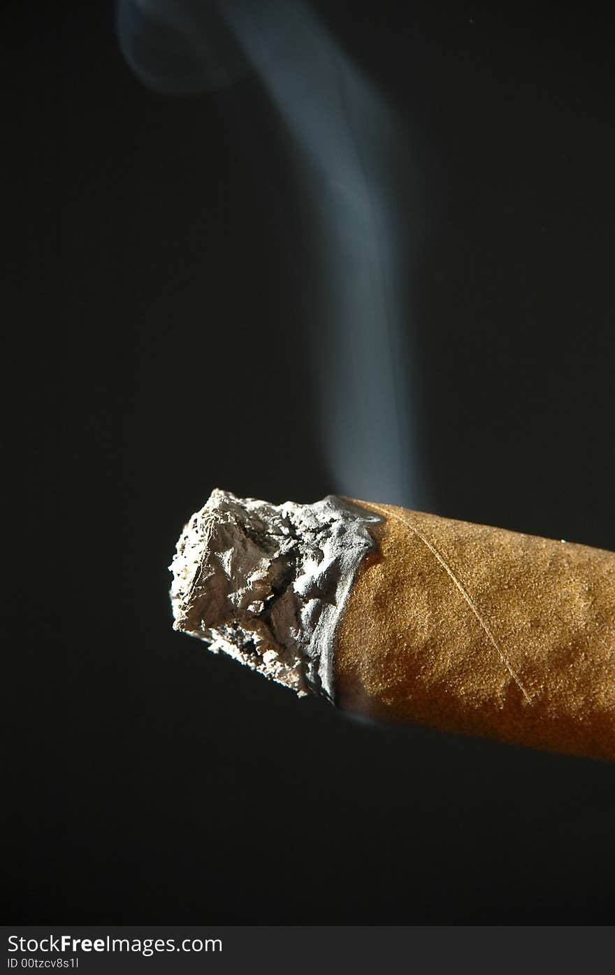 A smoking, cigar with ashes on a dark background. A smoking, cigar with ashes on a dark background