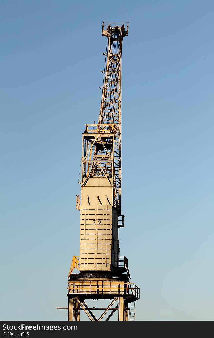 A dockside crane against a blue sky