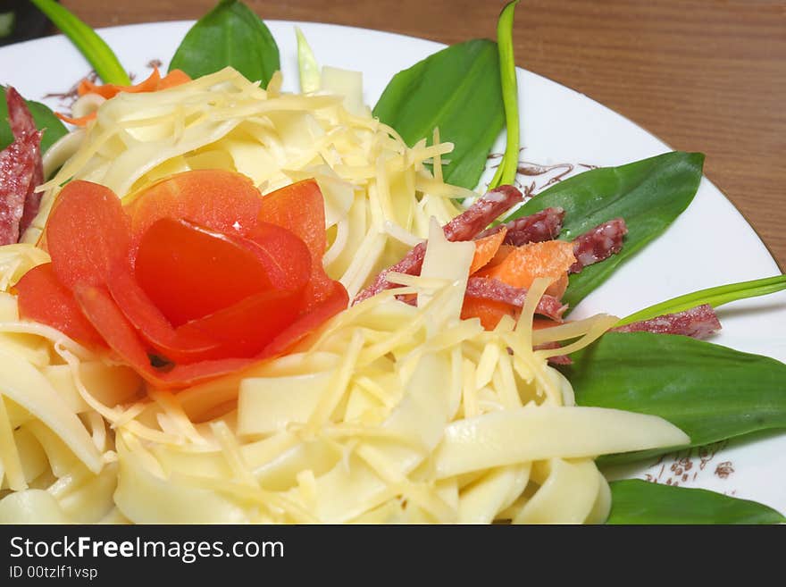 Pasta with cheese, salami, tomatoes and herbs