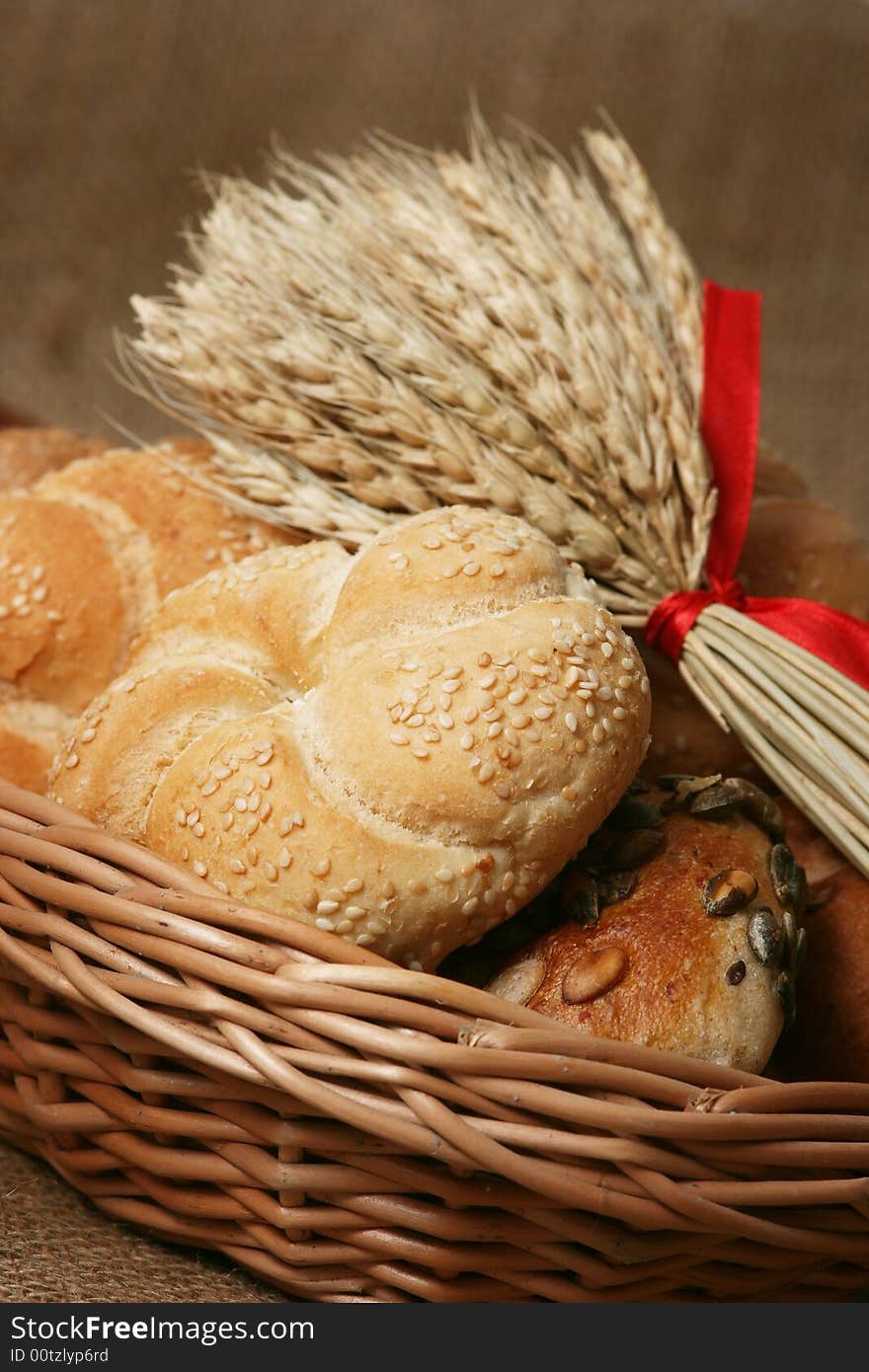 A closeup of a different bread with wheat grains and stalks placed next to it. A closeup of a different bread with wheat grains and stalks placed next to it.