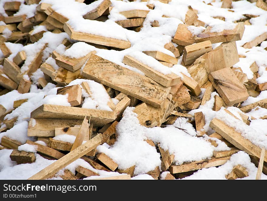 Heap of wooden planks (firewood) covered with snow - background. Heap of wooden planks (firewood) covered with snow - background.