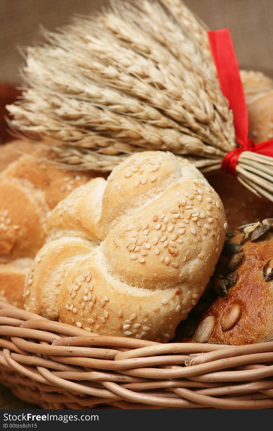 A closeup of a different bread with wheat grains and stalks placed next to it. A closeup of a different bread with wheat grains and stalks placed next to it.