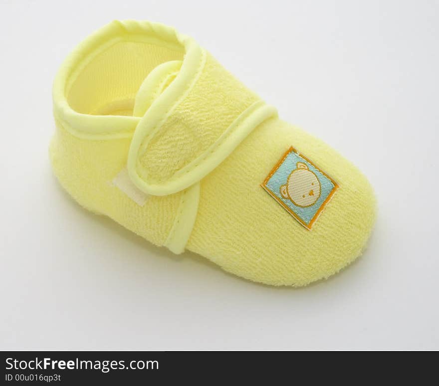 One babies shoe in a yellow towelling fabric