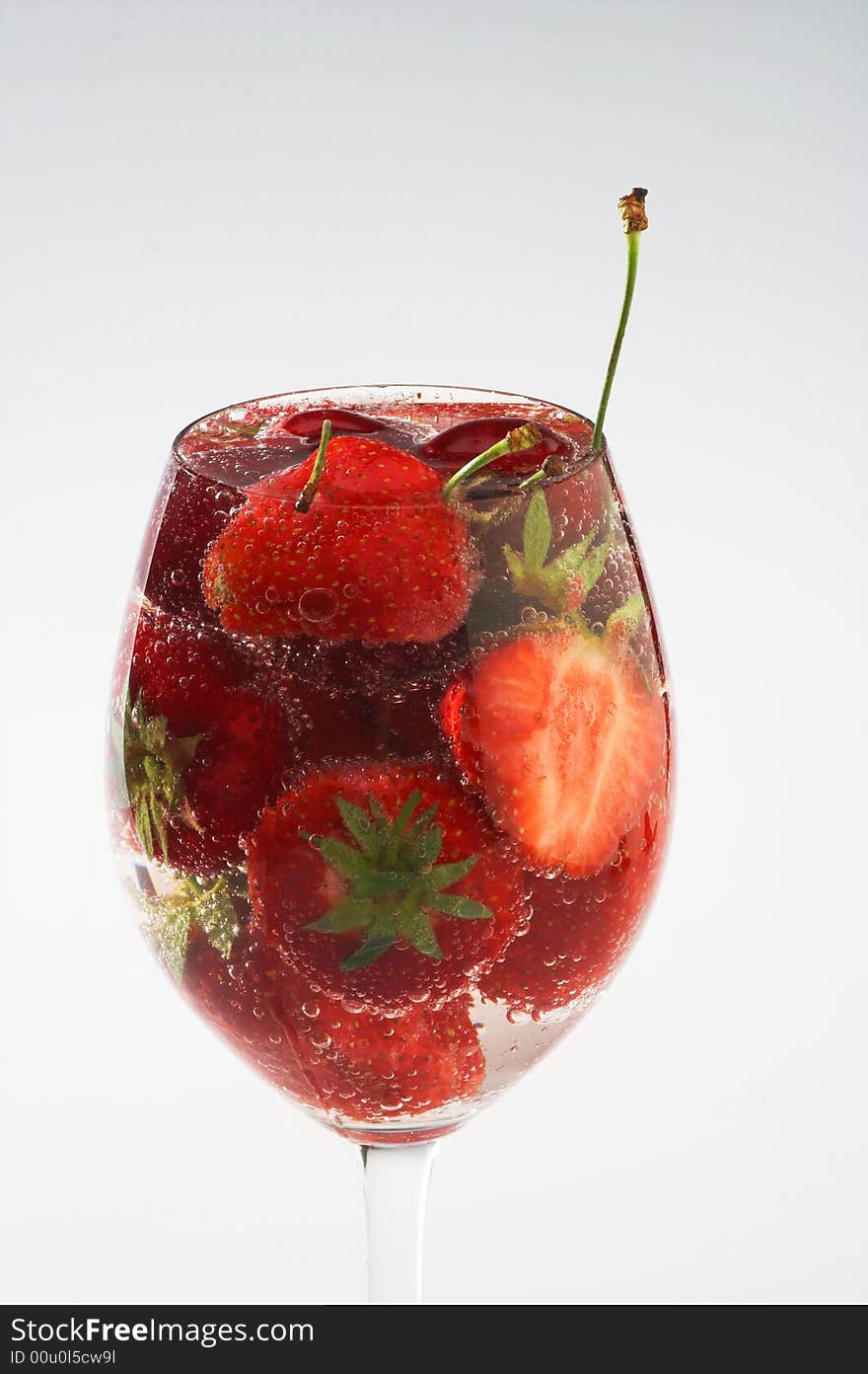 Strawberry and cherry in white glass filled with water. Strawberry and cherry in white glass filled with water