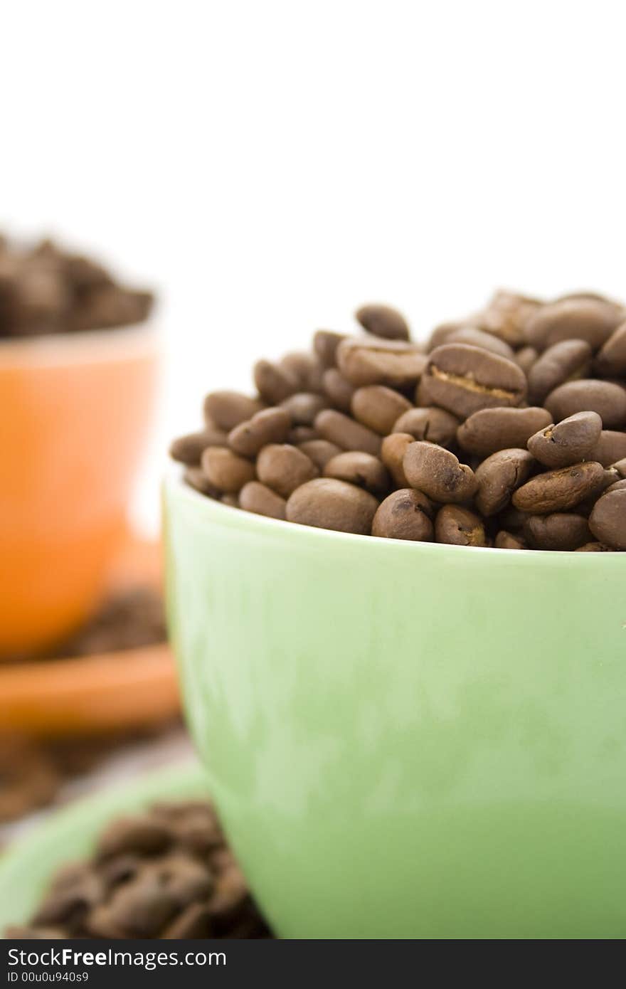 Coffee beans in green and orange cup