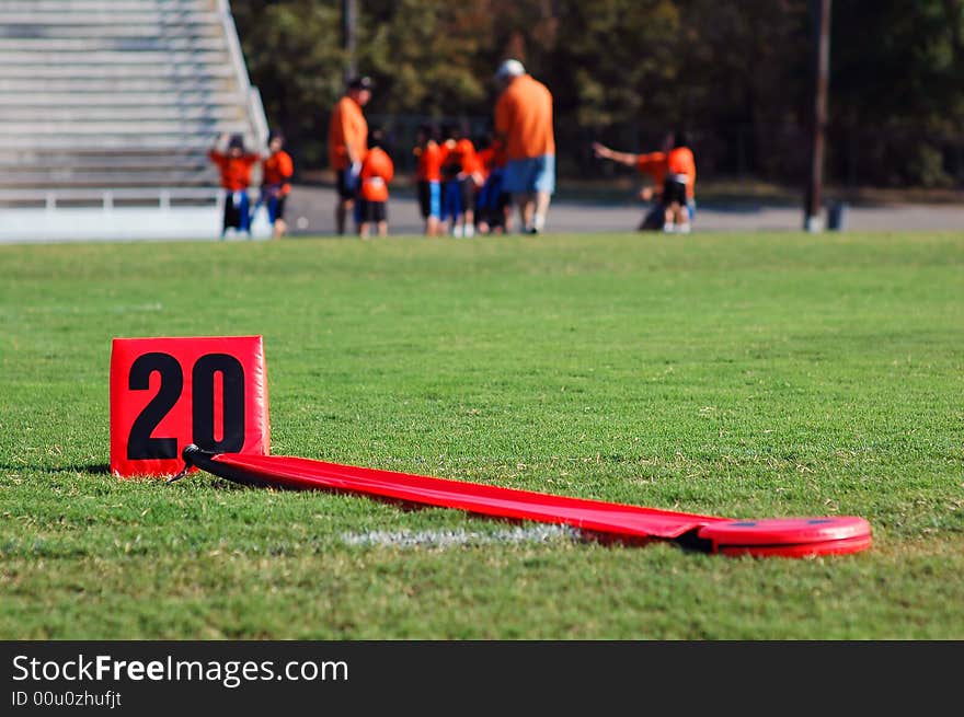 A young flag football team huddles near the 20 yard line. A young flag football team huddles near the 20 yard line.