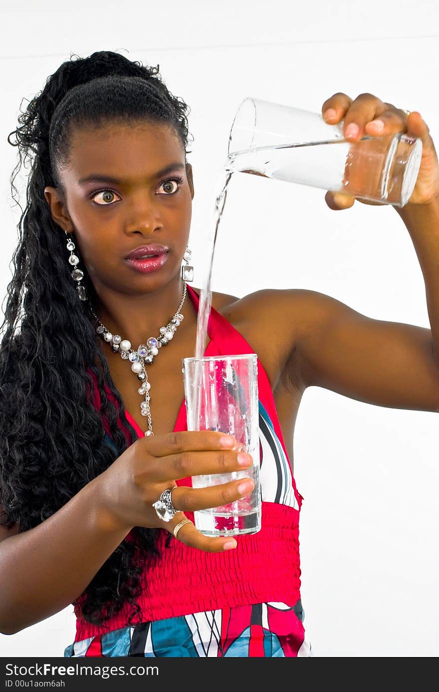 Sweet african girl pouring water into a glass. Sweet african girl pouring water into a glass