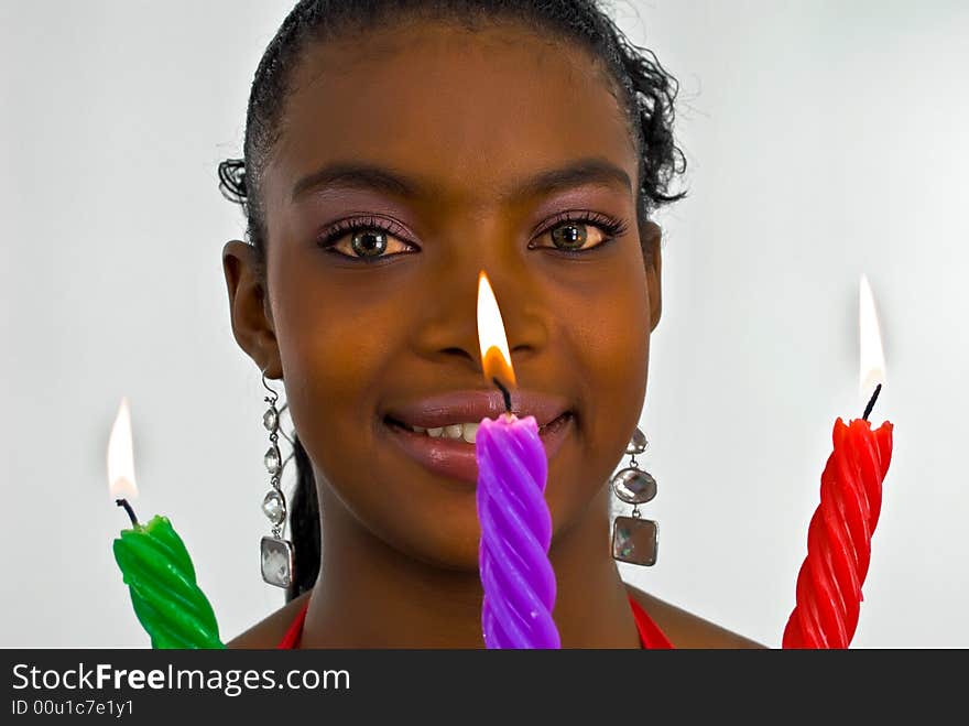 Beautiful young woman with three colored candles