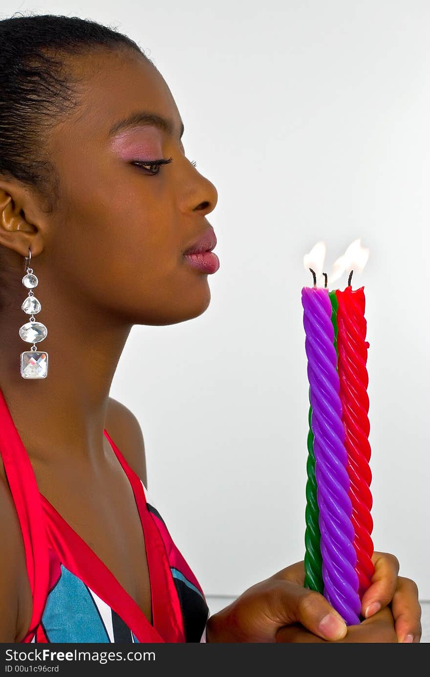 Beautiful young woman with three colored candles