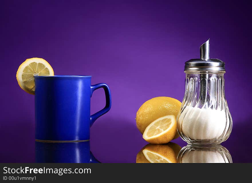 A blue cup of tea with lemons and sugar