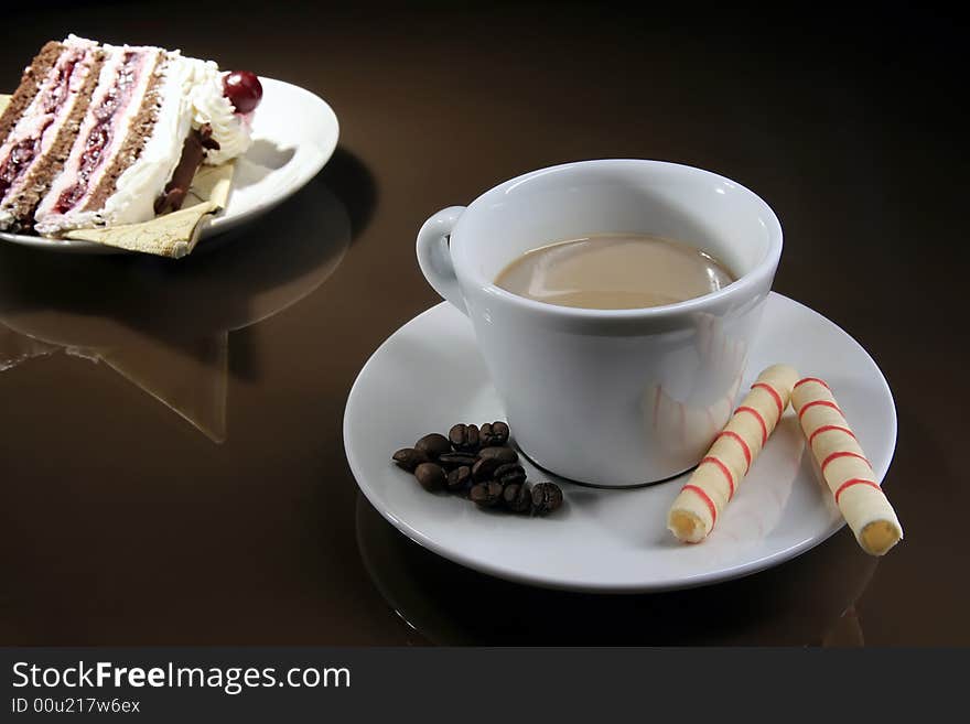 Piece of cake and cup of coffee with two rolls. Piece of cake and cup of coffee with two rolls