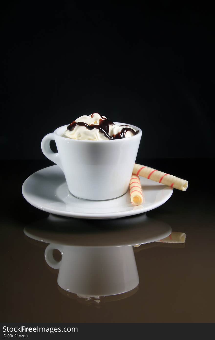 A cup of coffee with two rolls on the black background. A cup of coffee with two rolls on the black background