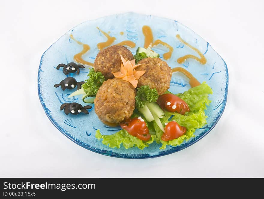 Meat balls for kids on a blue transparent plate with little crabs made out of black olives and red tomatoes.