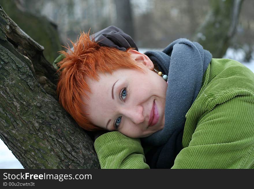 A beautiful blue eyed young woman near tree