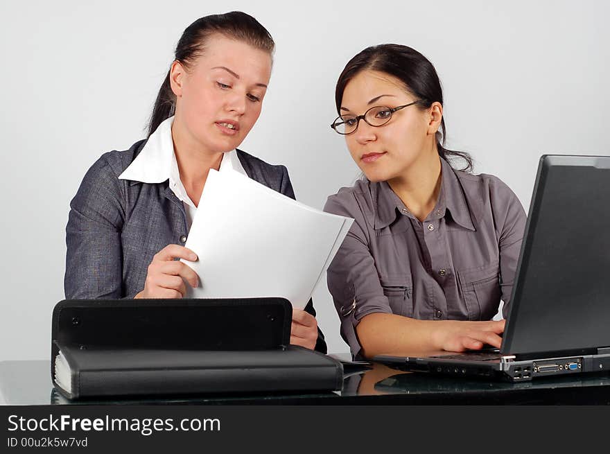 Two attractive brunette women working in office. Two attractive brunette women working in office