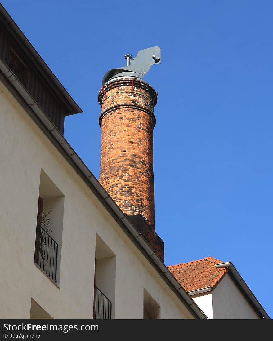 Brick chimney on a roof in the old historical Bavarian City Wasserburg .Blue Sky as backround . Brick chimney on a roof in the old historical Bavarian City Wasserburg .Blue Sky as backround .