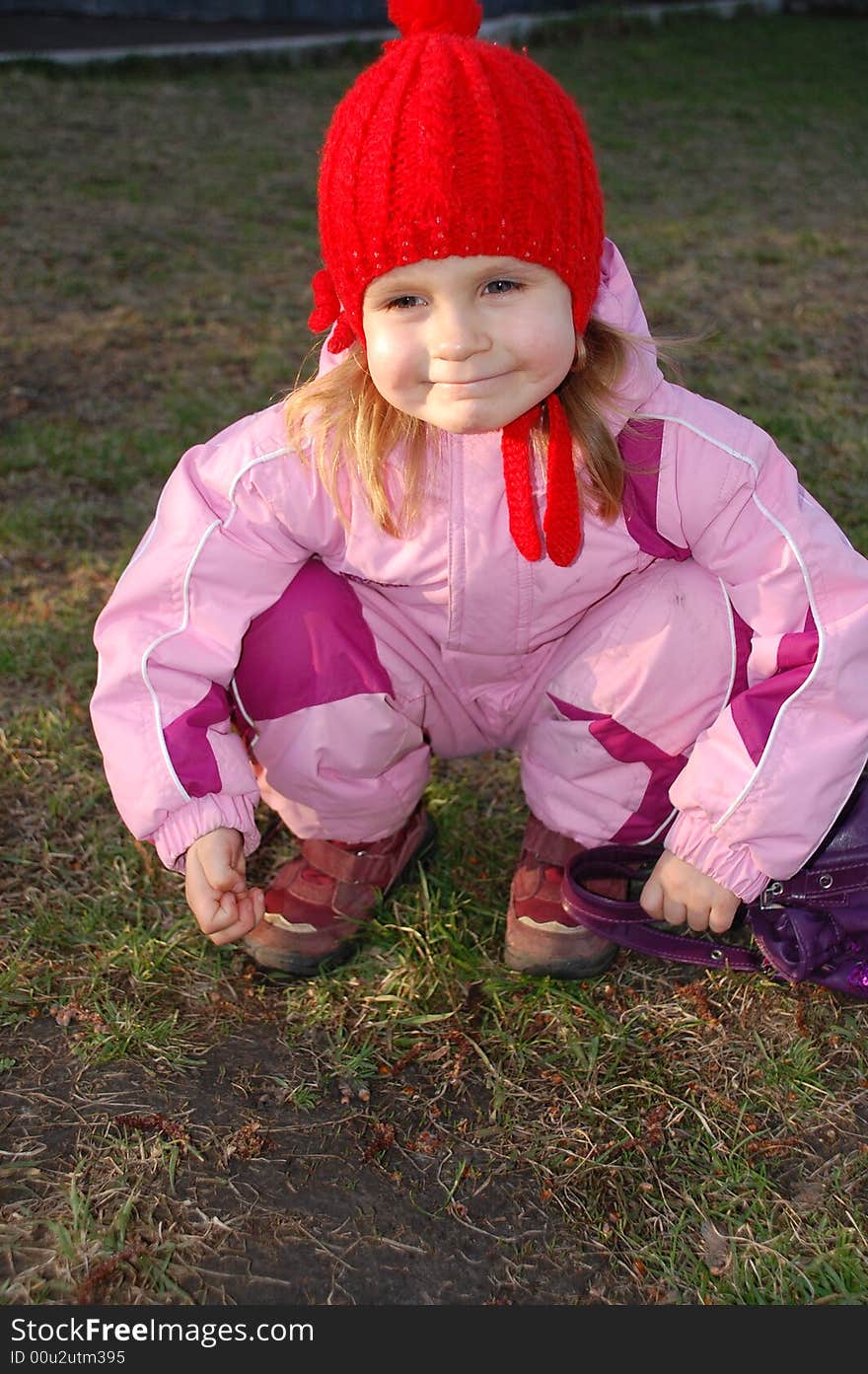 Happy sitting girl in a red hat