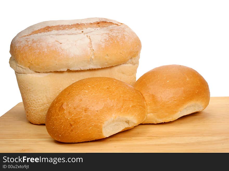 Bread loaf and rolls on wooden board