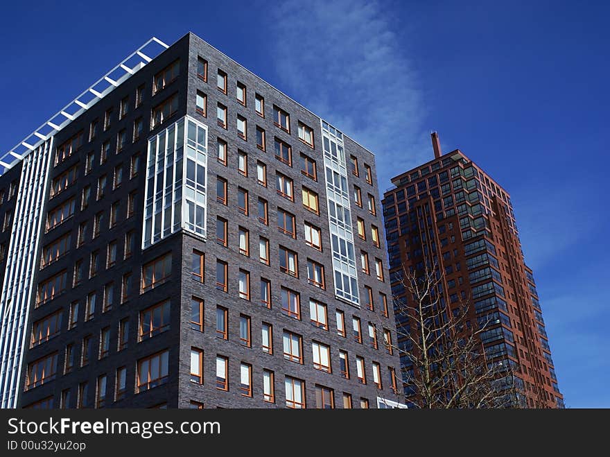 Two large buildings against a blue sky. Two large buildings against a blue sky.