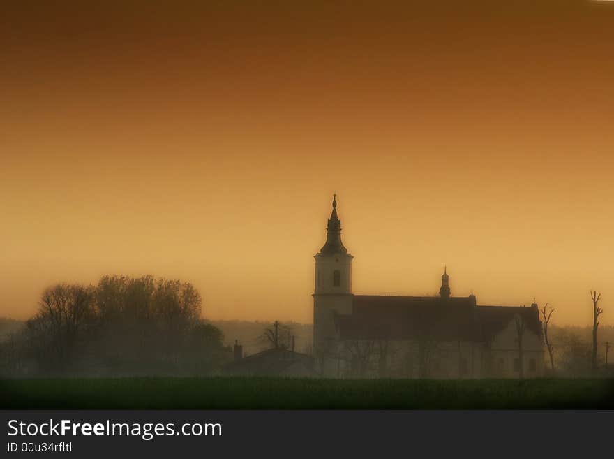 Church between fields in the cloudy day