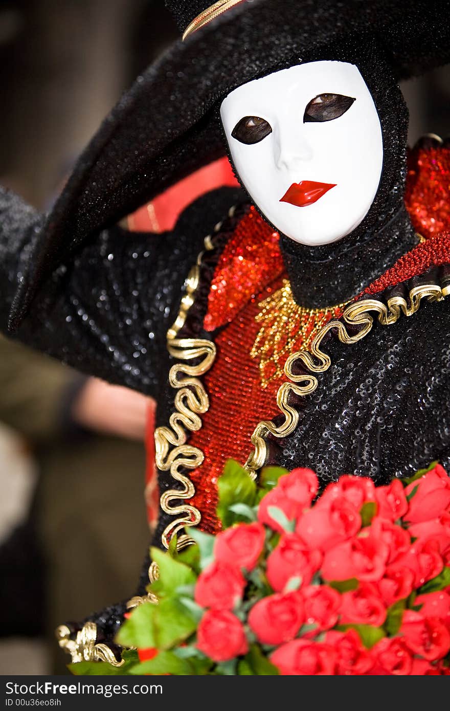 Stylish venetian women in costume with a bunch of roses