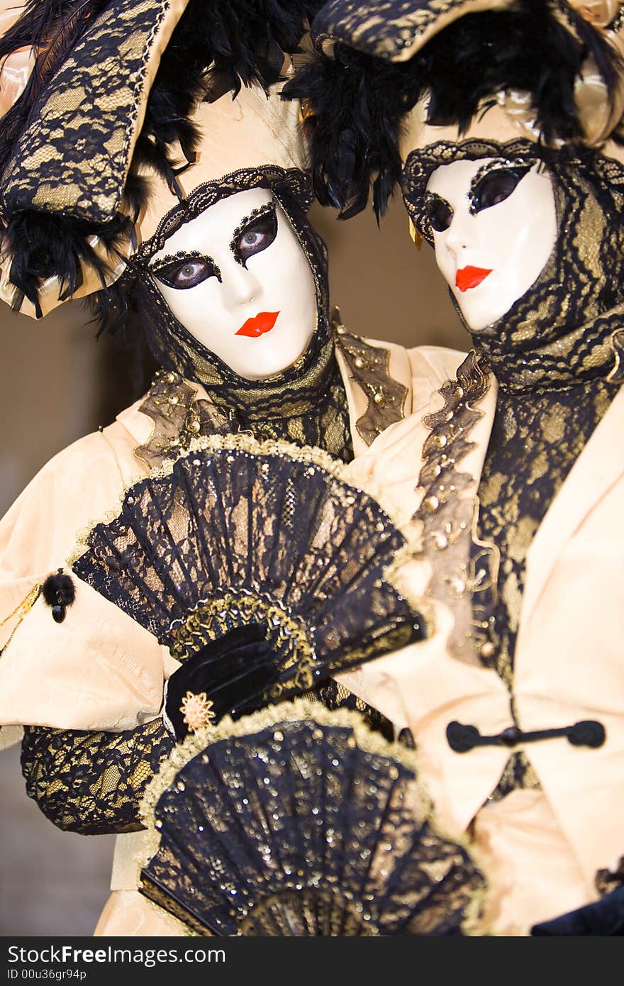 Two people in cream costumes at the Venice Carnival. Two people in cream costumes at the Venice Carnival