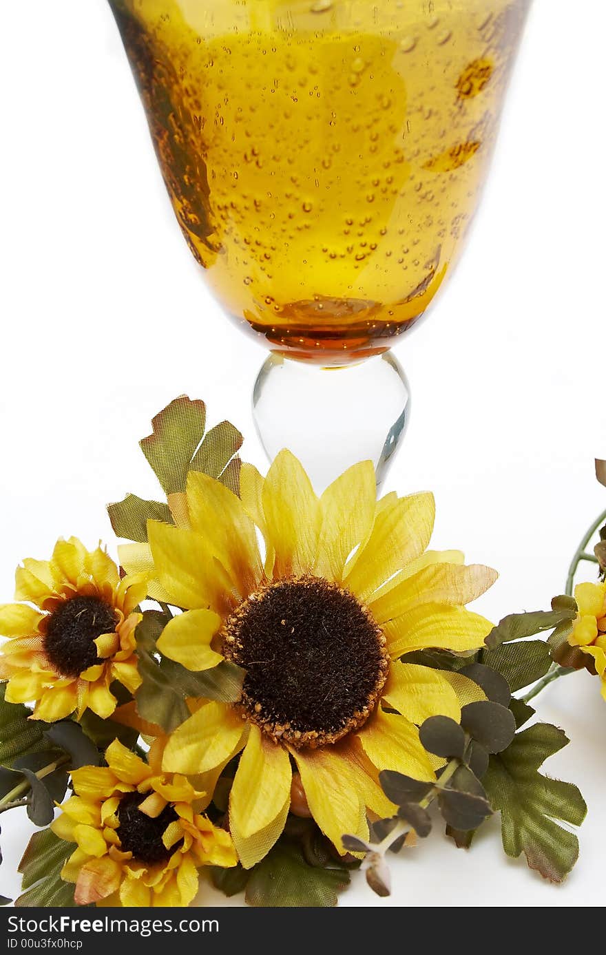 Big yellow wineglass with artificial sunflowers