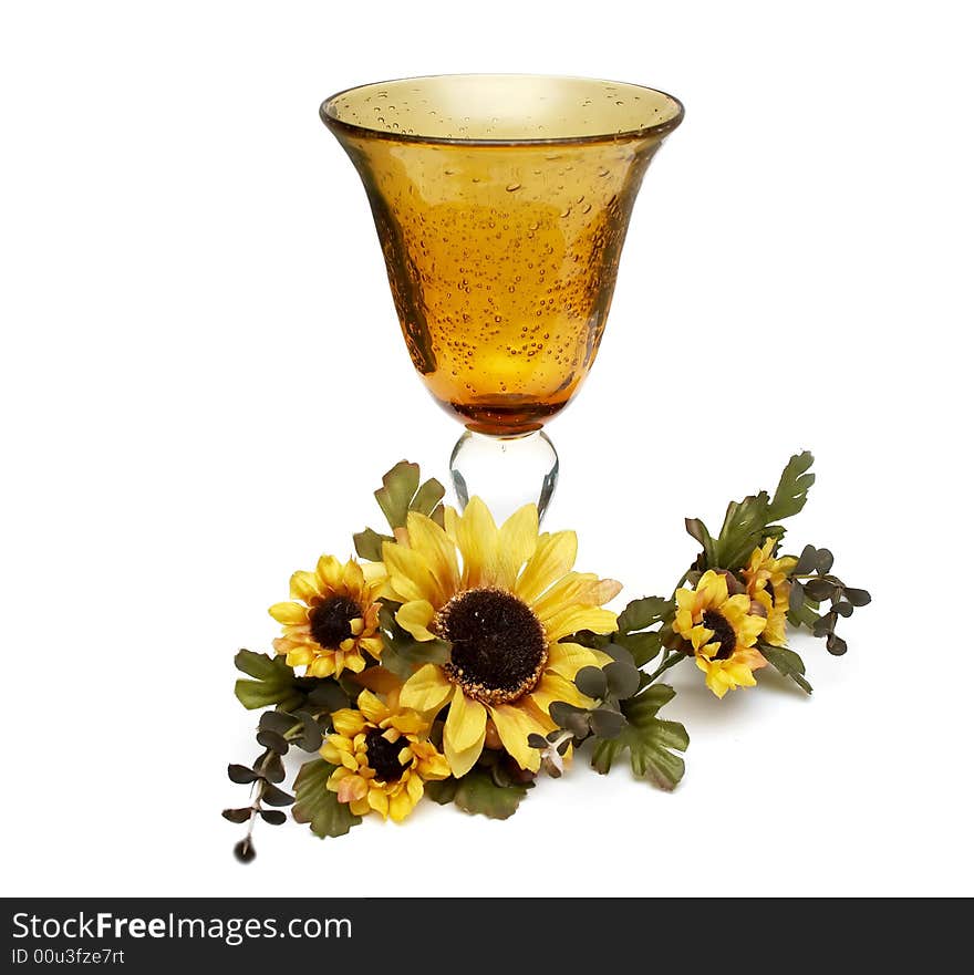 Big yellow wineglass with artificial sunflowers