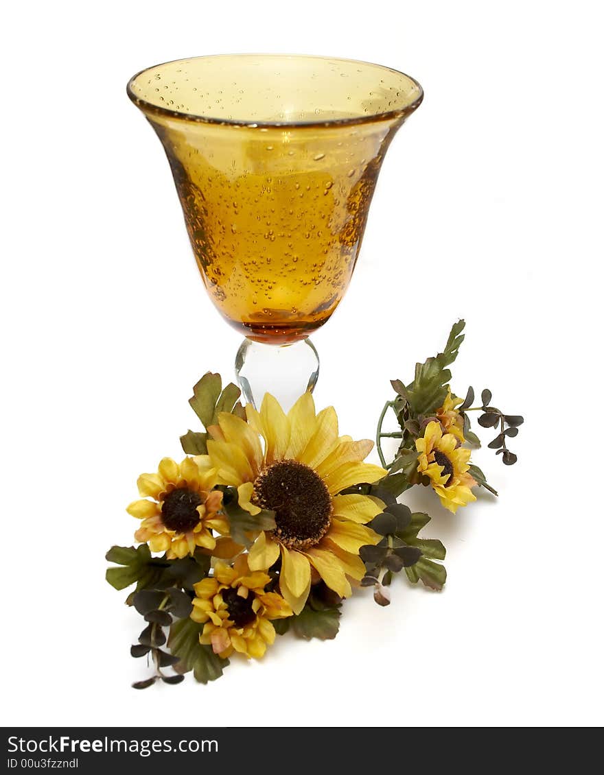 Big yellow wineglass with artificial sunflowers